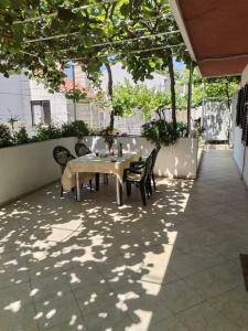 een tafel en stoelen op een patio met bomen bij APARTMENTS ANDREA in Dubrovnik