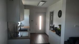 a room with a kitchen and a hallway with a door at Apartma Lima in Ankaran