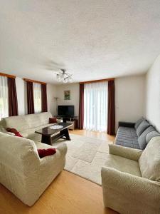 Sala de estar con 2 sofás y mesa en Unique Una, en Ripač
