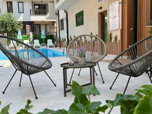 a patio with two chairs and a table with flowers at Tabanov Beach Hotel in Sozopol