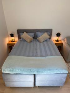 een groot bed met twee nachtkastjes ernaast bij Lux Studio HOTEL in Keyla