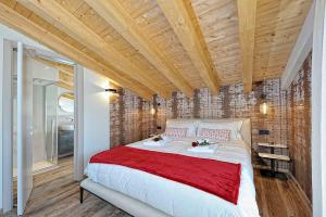 a bedroom with a large bed with a wooden ceiling at Lux Domotic Apt-Chalet Dolomites in Pinzolo