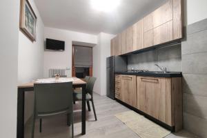 cocina con mesa con sillas y encimera en Tur Appartamenti, en Padola