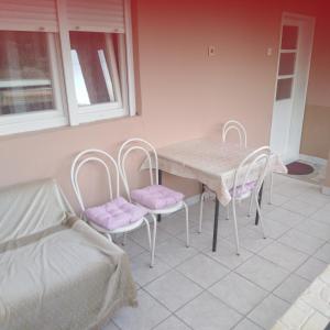uma sala de jantar com uma mesa e duas cadeiras em Janina Hiša em Stolac