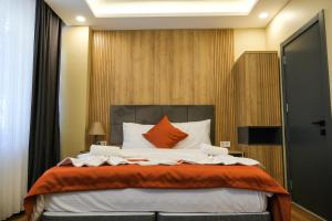 1 dormitorio con 1 cama grande con almohadas de color naranja y blanco en hotel La Vitrine, en Estambul
