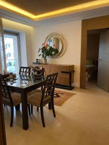 a dining room with a table and chairs and a mirror at Appartement luxueux haut Agdal in Rabat