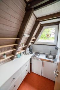 una cucina in una casetta minuscola con finestra di Ferienhaus Rhön-Auszeit a Bischofsheim an der Rhön