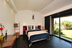 a bedroom with a bed and a large window at Domaine Pozzo di Mastri in Figari