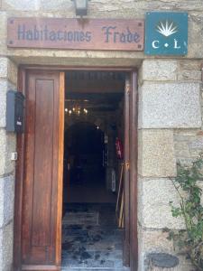 a door to a building with a sign above it at Habitaciones Frade in O Cebrero +3 photos