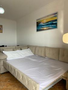 a large white bed in a room with a couch at The Blue Pearl Apartment in Durrës