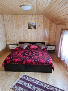 a bedroom with a bed in a wooden room at Casa Faurului 