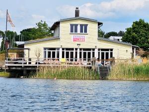 a house on the water next to a body of water at Seezeit - gemütliche Ferienwohnung, Tiefgarage, Cospudener See in Markkleeberg