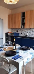 een keuken met een tafel met borden en een fles wijn bij CIVICO 38. Vista mare, modernità e confort a soli 2 minuti a piedi dalla spiaggia. in Montesilvano