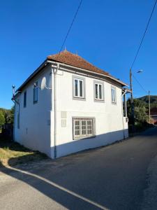 una casa blanca al lado de una carretera en Vila Feliz 