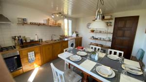 a kitchen with a table and chairs and a kitchen with a sink at Vila Feliz 