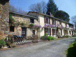 an old stone house with purple flowers on it at Les Petites Pierres- rural + wifi,pool(shared),games field in Vernoux-en-Gâtine