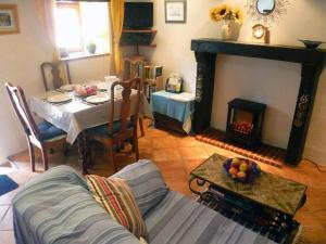 a living room with a table and a fireplace at Les Petites Pierres- rural + wifi,pool(shared),games field in Vernoux-en-Gâtine