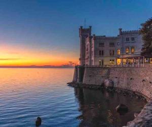 um castelo na costa de um corpo de água em [Ospedale Maggiore] - Dimora Zen em Trieste