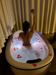 a woman sitting in a bath tub with a glass of wine at Valle Piemonte in Divisa
