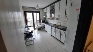 a kitchen with white cabinets and a table and a chair at Ata in Istanbul