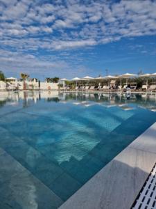 a swimming pool with blue water in a resort at Fantinello Hotel in Caorle