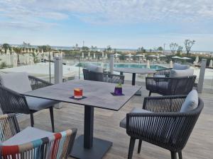 a patio with tables and chairs and a pool at Fantinello Hotel in Caorle