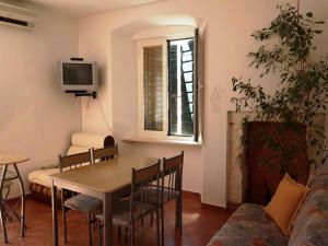 a living room with a table and chairs and a tv at Central Sibenik Apartments in Šibenik