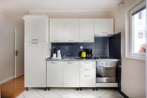 cocina blanca con fregadero y nevera en Dream Apartment Solitudo, en Dubrovnik