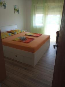 a bedroom with a large bed with a wooden floor at Apartmani Marina in Rab