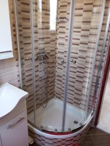 a shower with a glass enclosure in a bathroom at Apartmani Marina in Rab