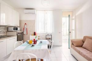 a white kitchen with a table and a couch at Stella Marina in Scilla