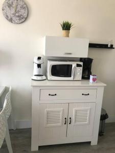 a white cabinet with a microwave on top of it at Les Issambres Superbe studio avec terrasse in Roquebrune-sur-Argens
