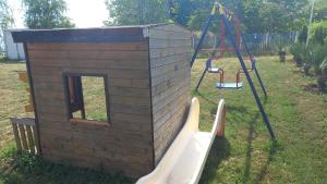 a play house and a slide in a yard at Pomorie Direkt am Pool in Pomorie