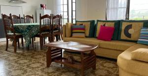 un soggiorno con divano, tavolo e sedie di Chez Camille et Alexis a La Plaine-des-Palmistes