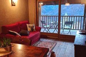 a living room with a red couch and a balcony at Casa La Talpa Dispettosa in Cesani