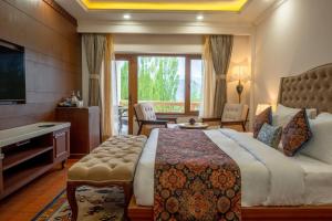 a hotel room with a large bed and a television at Hotel Gyalpo Residency - A Mountain View Luxury Hotel in Leh in Leh