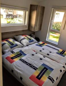 - 2 lits installés l'un à côté de l'autre dans une chambre dans l'établissement Spatzennest Beach Chalet 22, à Scharbeutz