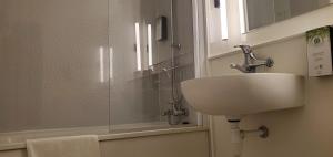 y baño con lavabo y ducha. en KYRIAD HONFLEUR - La Riviere Saint Sauveur, en Honfleur