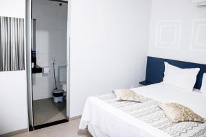 a bedroom with a white bed and a shower at PARIS HOTEL in Barreiras