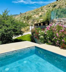 una piscina in un cortile fiorito di La Casa de Cristal - Alpujarra Escape a Órgiva