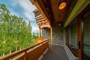 a balcony of a house with a view of trees at Hotel Gyalpo Residency - A Mountain View Luxury Hotel in Leh in Leh