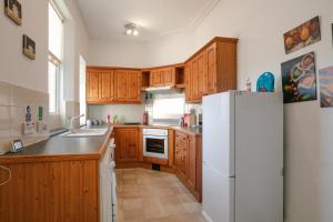 a kitchen with wooden cabinets and a white refrigerator at The Summit West End- Elegant Apartment with Free Parking in Prime Location in Aberdeen