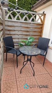 dwa krzesła i stół na patio w obiekcie SOPOT pokoje wakacyjne TOPOS City One w mieście Sopot
