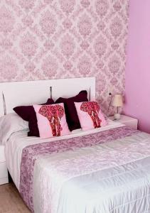 - une chambre avec un lit blanc aux murs roses dans l'établissement Jardines de Sinia, à Los Mártires