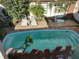 a swimming pool with two lawn chairs at Hostel Jardim da Saúde in Sao Paulo