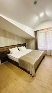 Un dormitorio con una cama grande y una ventana en Marrone Hotel Tsaghkadzor, en Tsaghkadzor