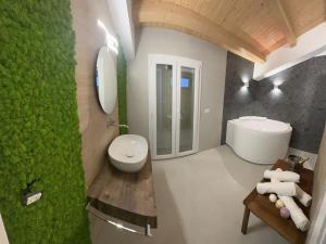 La salle de bains est pourvue de toilettes blanches et d'un lavabo. dans l'établissement LA MAIOLICA, à Pozzallo