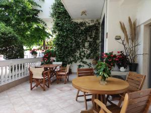 a patio with two tables and chairs and plants at Evripidis – Katerina Rooms –Β in Asprovalta +19 photos
