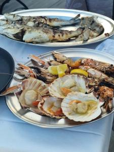 zwei Teller mit verschiedenen Arten von Meeresfrüchten auf einem Tisch in der Unterkunft Fantinello Hotel in Caorle