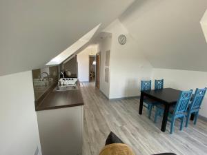 uma cozinha e sala de jantar com uma mesa e cadeiras azuis em Hazel View Apartment em Bunbeg